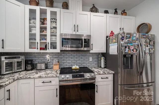 a kitchen with stainless steel appliances granite countertop a stove and a refrigerator
