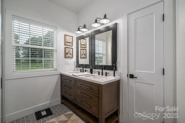 a bathroom with a double vanity sink and mirror with window
