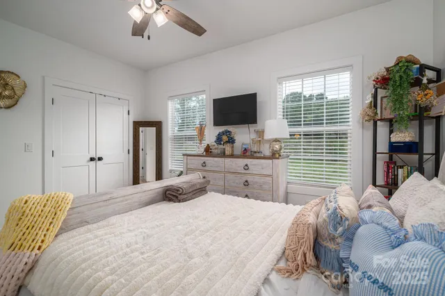 a bedroom with a bed window and a flat screen tv