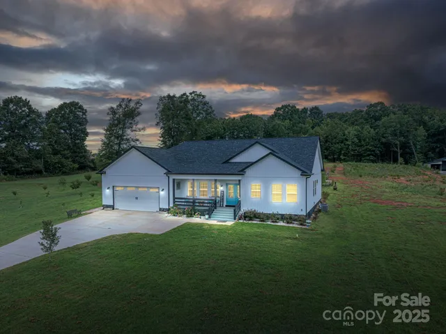 a front view of a house with a yard and trees