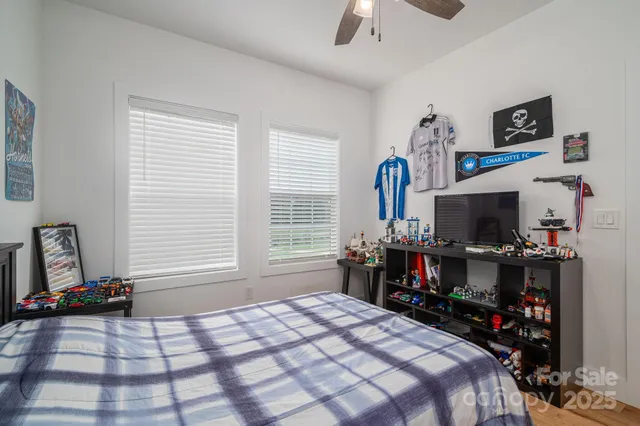 a bedroom with a bed a flat screen tv and a window