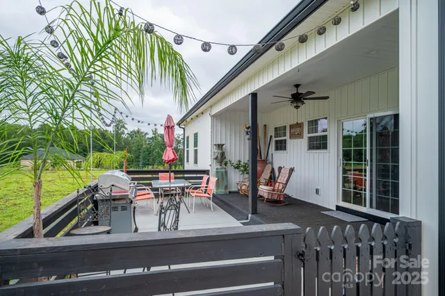 a view of a patio with table and chairs with wooden floor and fence