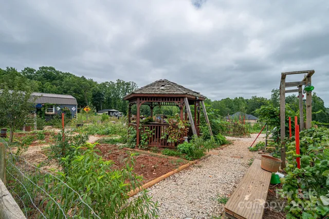 a view of a garden with a bench in front of the house