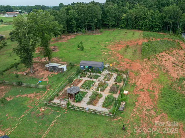 an aerial view of residential houses with outdoor space and trees