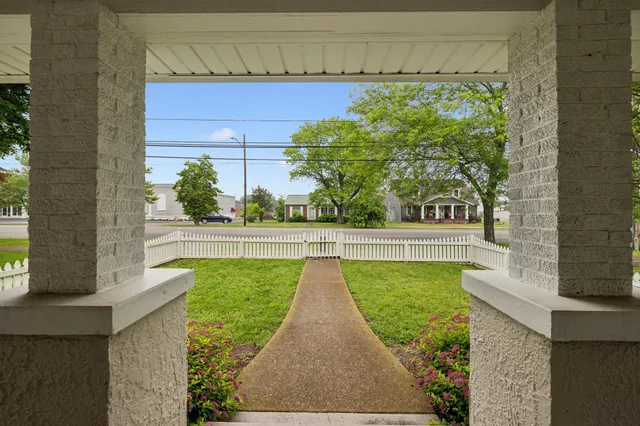 a view of a hallway with wooden floor and furniture