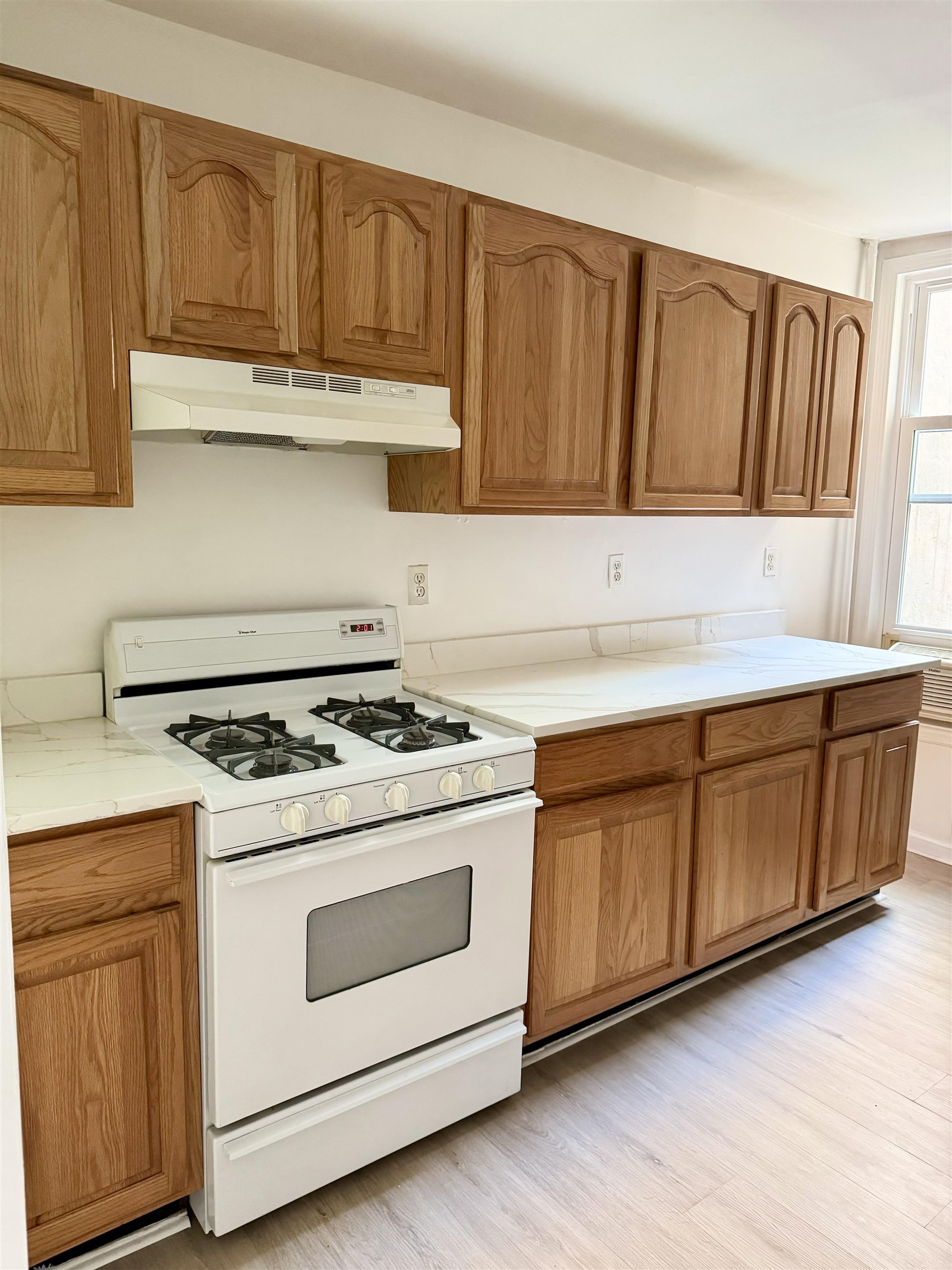 421 Adams Street, Unit 2L Hoboken, NJ 07030 - Photo 17 of 19 a kitchen with granite countertop wooden cabinets and white appliances