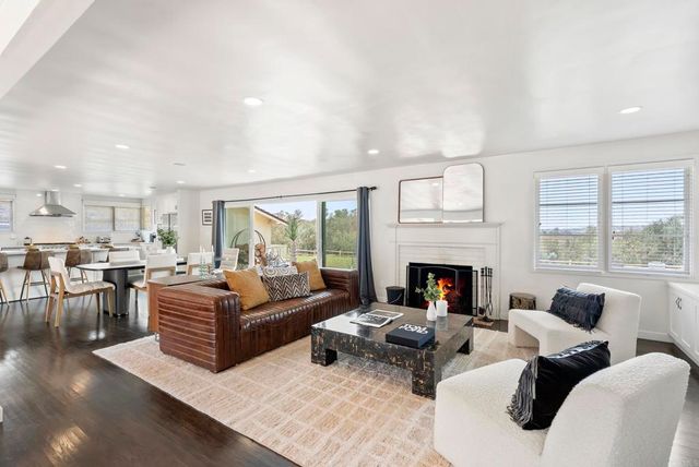 a living room with furniture fireplace and a large window