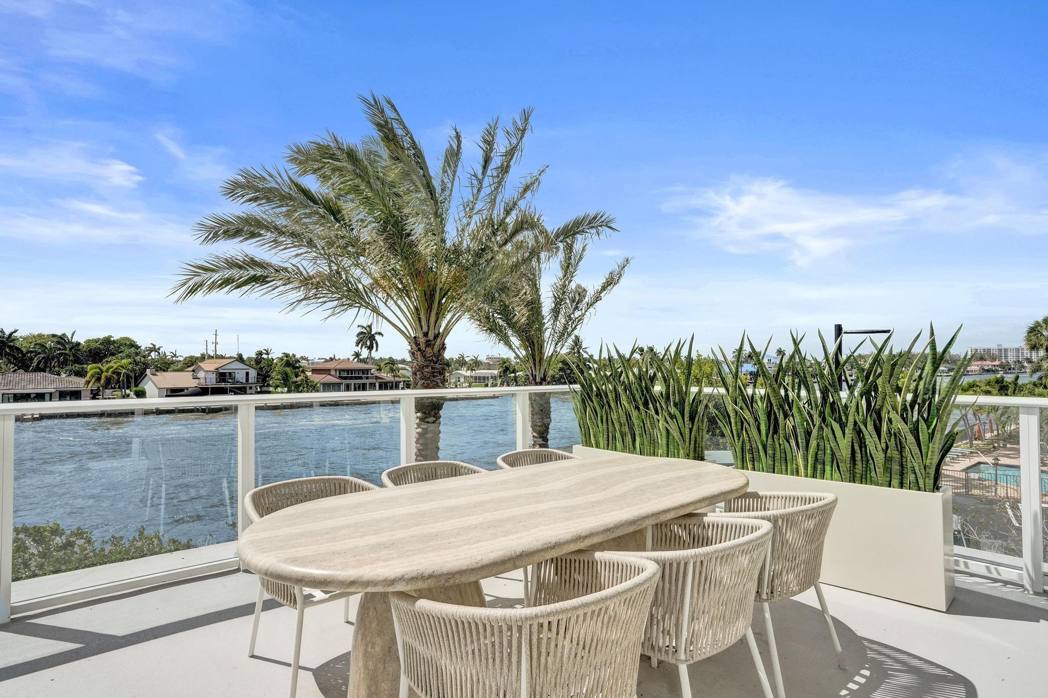 407 North Riverside Drive, Unit 203 Pompano Beach, FL 33062 - Photo 31 of 69 a view of a lake with table and chairs a barbeque grill with wooden fence