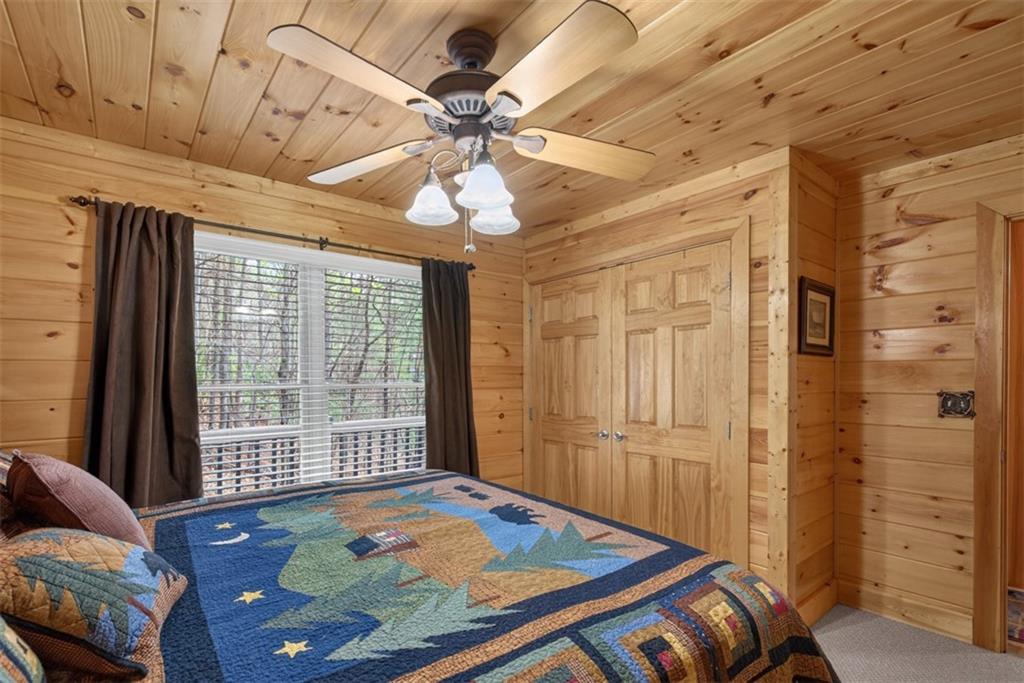 88 Crest Road Blairsville, GA 30512 - Photo 19 of 75 a bedroom with a bed and a chandelier