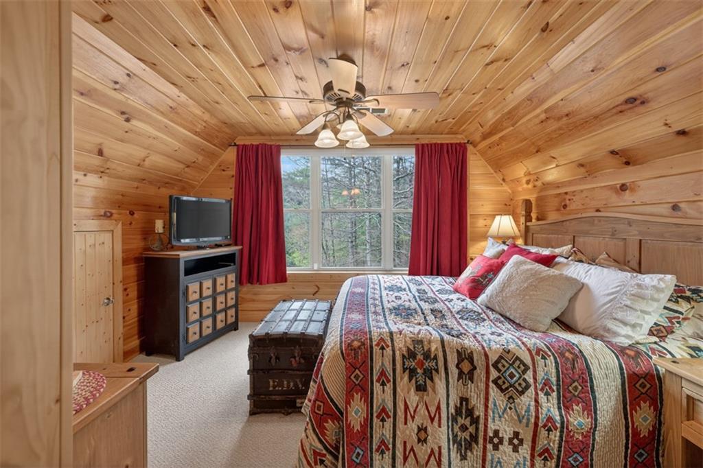 88 Crest Road Blairsville, GA 30512 - Photo 22 of 75 a bedroom with a bed and a chandelier