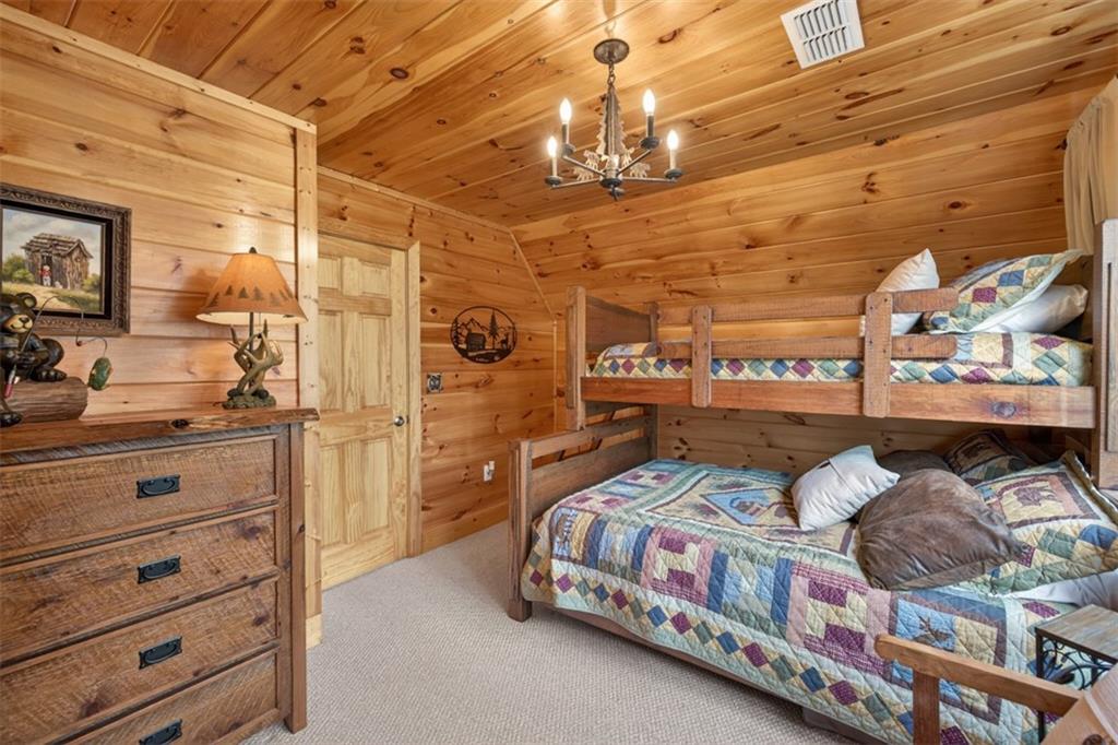 88 Crest Road Blairsville, GA 30512 - Photo 29 of 75 a bedroom with a bed and a chandelier