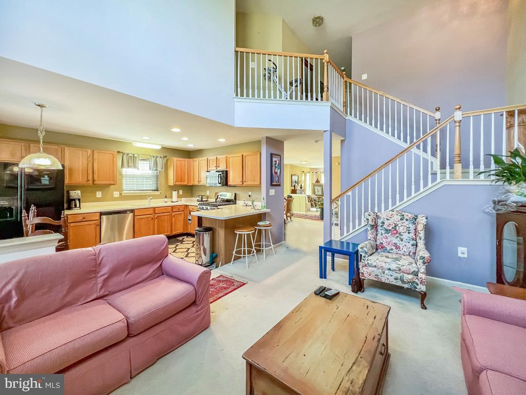 201 Raintree Crossing Hatfield, PA 19440 - Photo 15 of 46 a living room with furniture kitchen view and a wooden floor