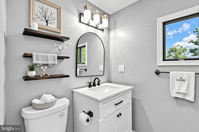 a bathroom with a toilet sink and mirror