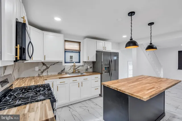 a kitchen with a sink a counter space and stainless steel appliances