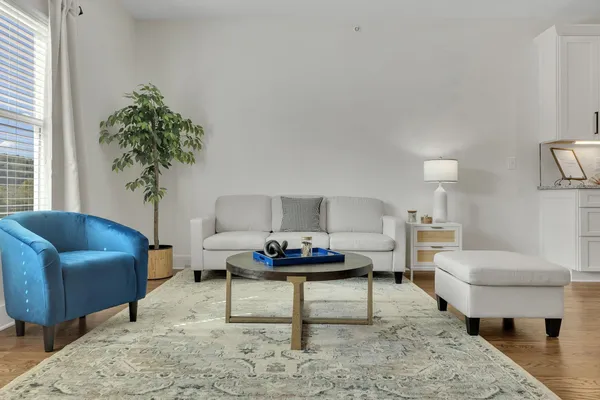 a living room with furniture and a view of kitchen