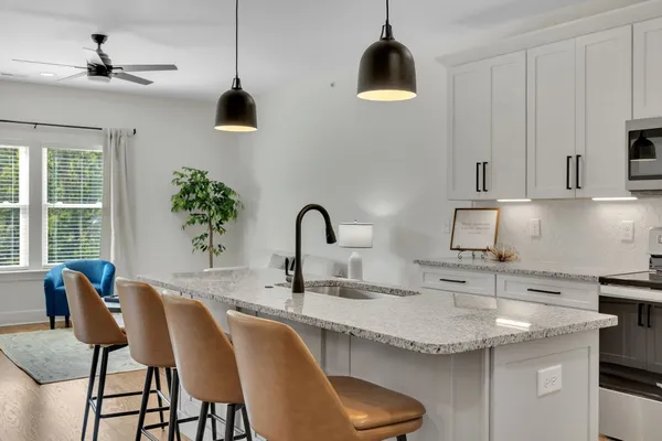 a kitchen with stainless steel appliances granite countertop a refrigerator a stove a sink a microwave and a refrigerator