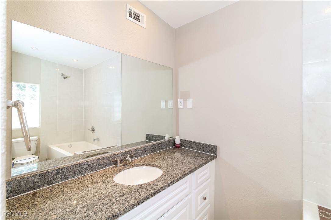 315 Ginger Road Venice, FL 34293 - Photo 9 of 16 a bathroom with a granite countertop sink and a mirror