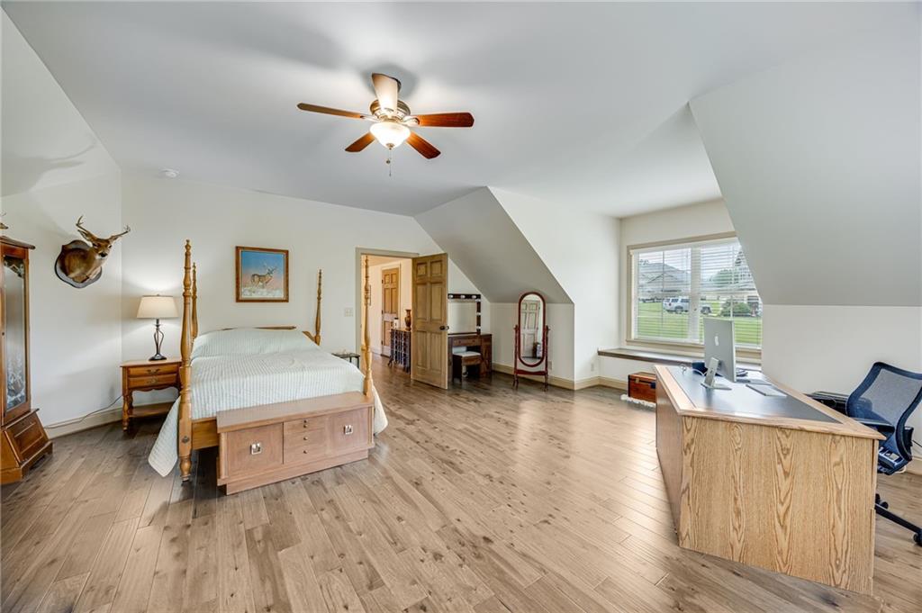 5911 Bent Tree Way Clermont, GA 30527 - Photo 47 of 56 a spacious bedroom with a bed and wooden floor