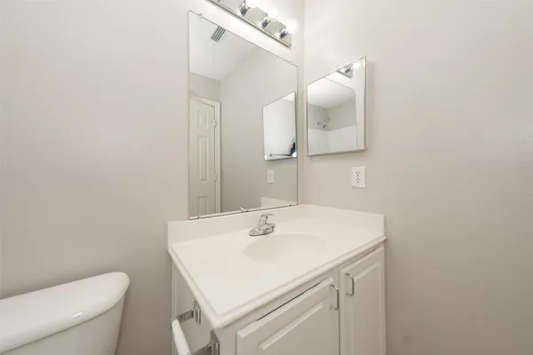 a bathroom with a sink vanity and toilet