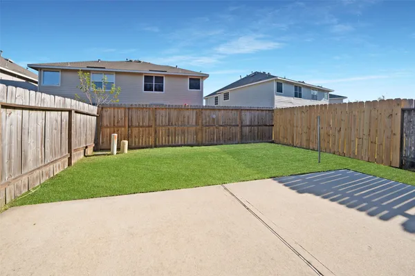 a view of a backyard with wooden fence