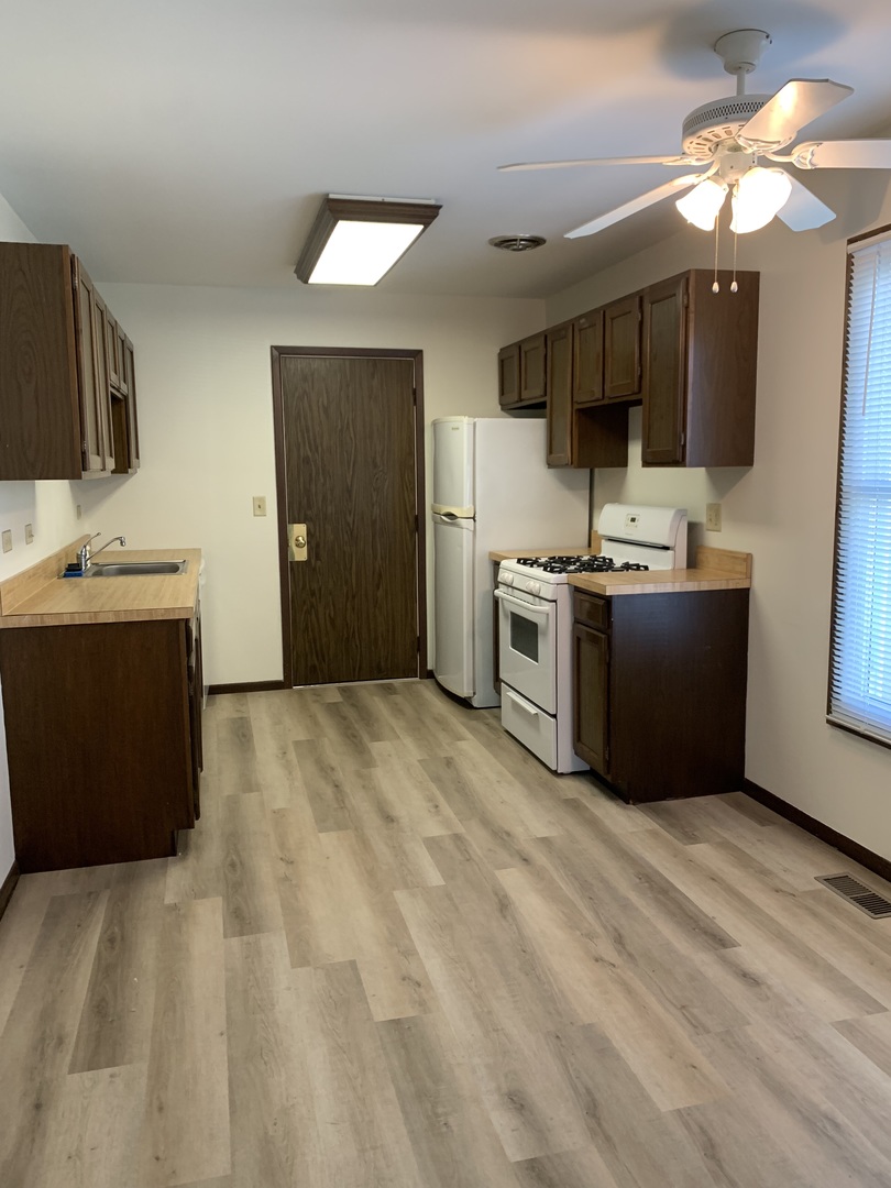 1068 Glouchester Harbor, Unit 1068 Schaumburg, IL 60193 - Photo 8 of 26 a kitchen with stainless steel appliances a stove top oven a sink dishwasher and a refrigerator with wooden floor