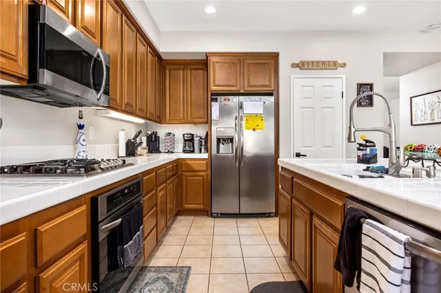 a kitchen with stainless steel appliances granite countertop a stove a sink dishwasher and a refrigerator