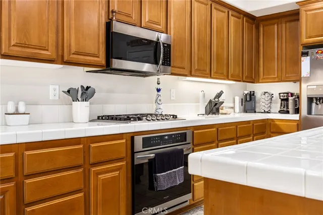 a kitchen with stainless steel appliances granite countertop a sink a stove microwave and cabinets