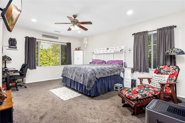 a living room with a bed furniture and a flat screen tv