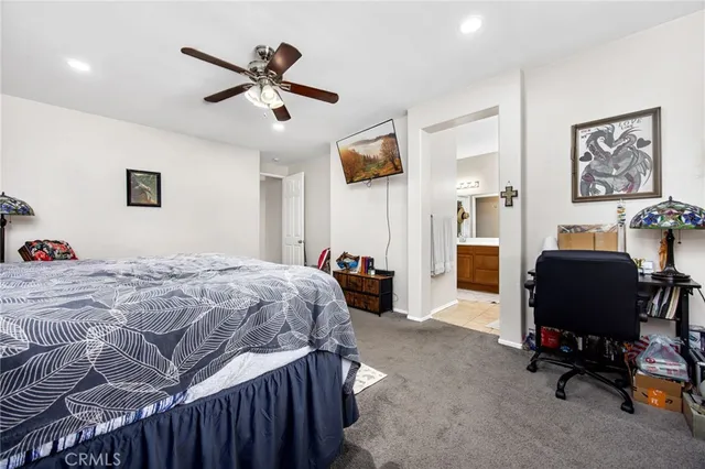 a bedroom with a bed a desk and chair with the bookshelf