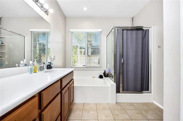 a spacious bathroom with a tub a sink and a mirror