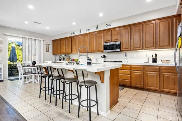 a kitchen with stainless steel appliances granite countertop a stove a sink a microwave and a refrigerator