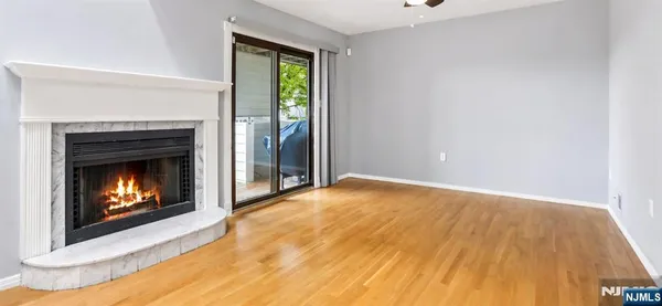 a view of empty room with wooden floor and fireplace
