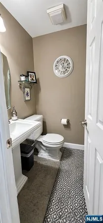 a bathroom with a sink a toilet and a mirror