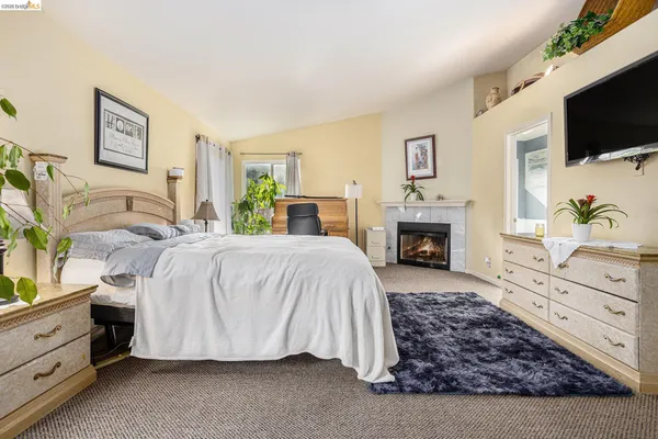 a spacious bedroom with a bed and a flat screen tv