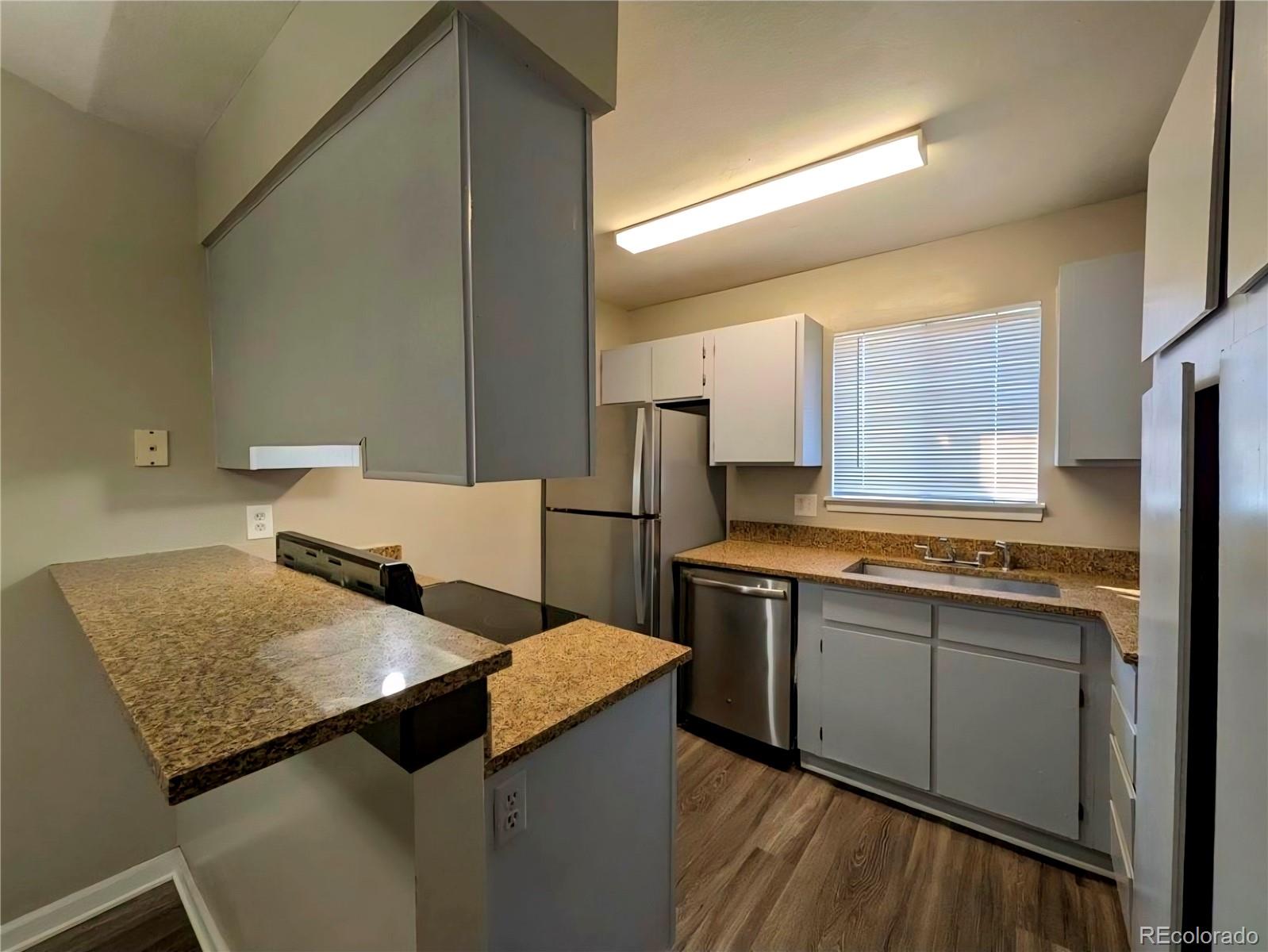 2231 South Buckley Road, Unit 202 Aurora, CO 80013 - Photo 2 of 10 a kitchen with a sink refrigerator and cabinets