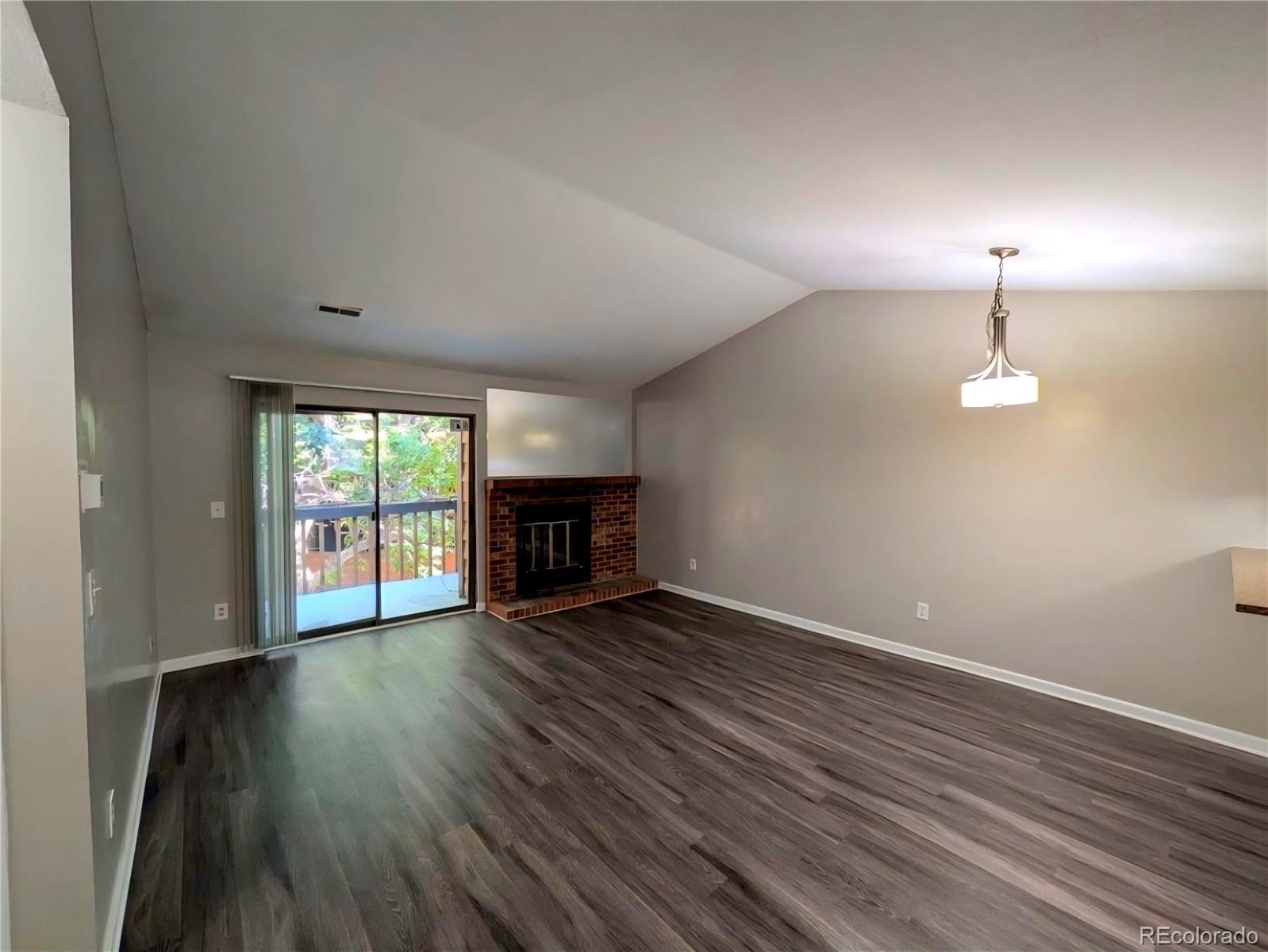 2231 South Buckley Road, Unit 202 Aurora, CO 80013 - Photo 3 of 10 an empty room with wooden floor fireplace and windows