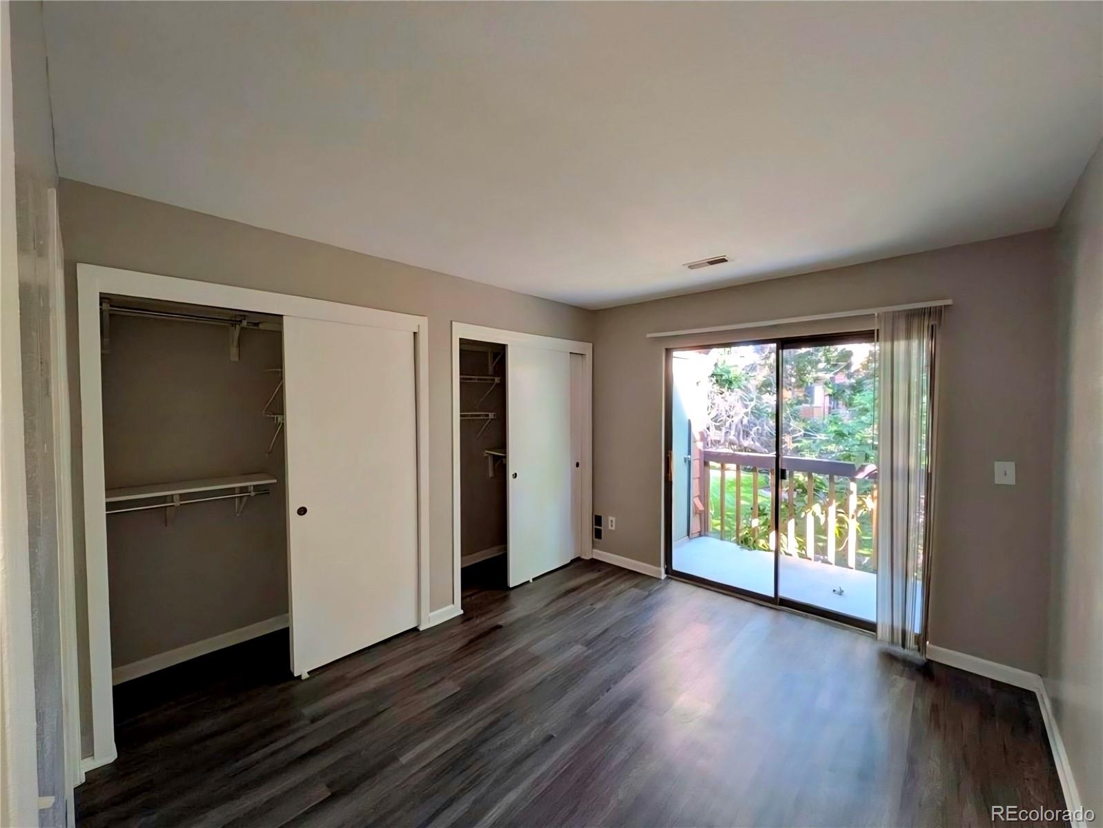 2231 South Buckley Road, Unit 202 Aurora, CO 80013 - Photo 5 of 10 a view of an empty room with wooden floor and a window