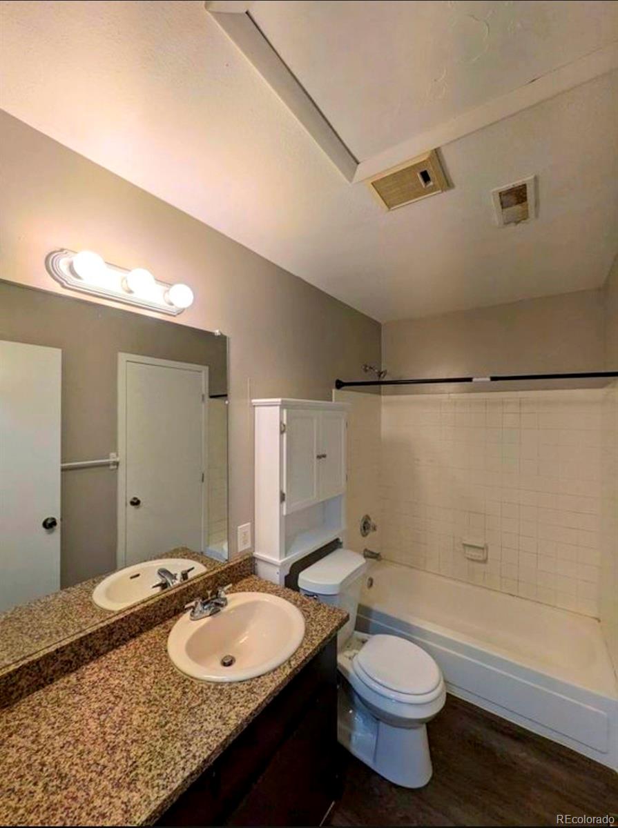2231 South Buckley Road, Unit 202 Aurora, CO 80013 - Photo 9 of 10 a bathroom with a granite countertop sink toilet a mirror and bathtub