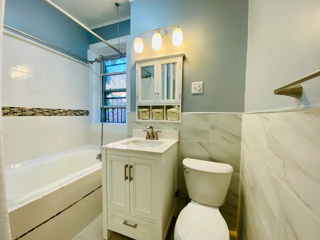 a bathroom with a toilet sink and mirror