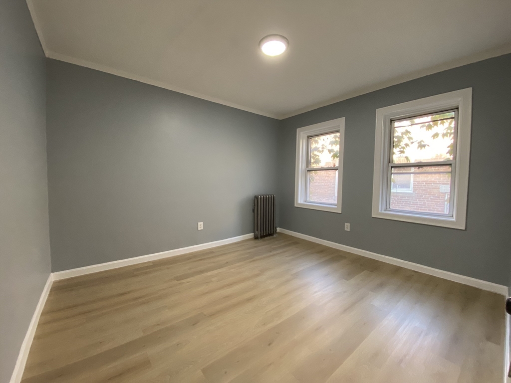 31 Queensberry Street, Unit 19 Boston, MA 02215 - Photo 2 of 6 a view of an empty room with wooden floor and a window