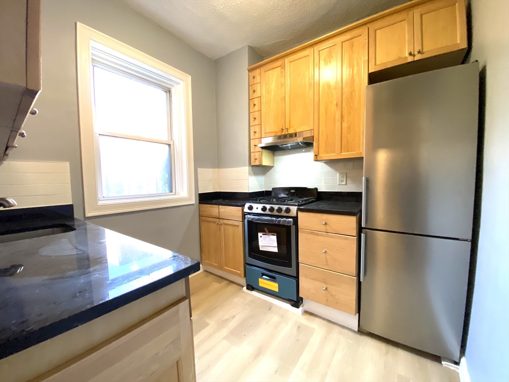 31 Queensberry Street, Unit 19 Boston, MA 02215 - Photo 3 of 6 a kitchen with stainless steel appliances granite countertop a refrigerator a sink and a stove