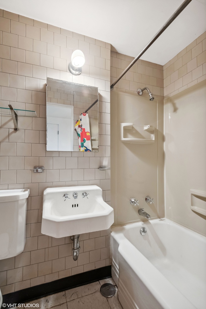 43 East Elm Street Chicago, IL 60611 - Photo 15 of 17 a bathroom with a tub a sink and mirror