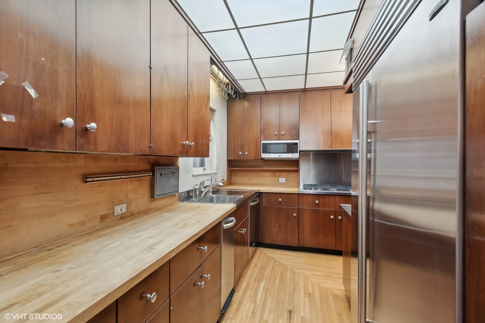 43 East Elm Street Chicago, IL 60611 - Photo 5 of 17 a kitchen with kitchen island granite countertop a sink stainless steel appliances wooden floor and cabinets
