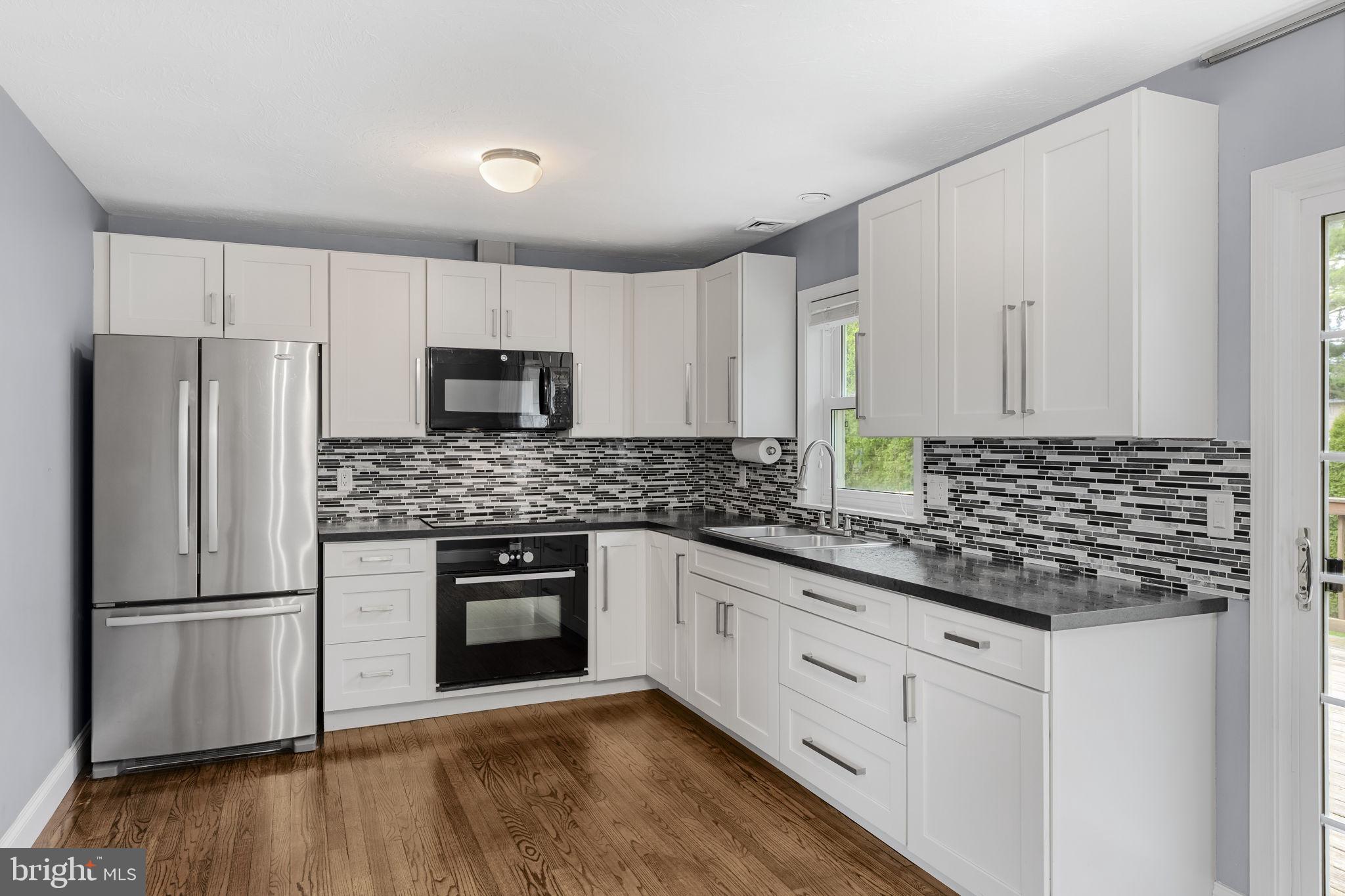 305 Partridge Drive Lititz, PA 17543 - Photo 7 of 46 a kitchen with stainless steel appliances white cabinets and wooden floor