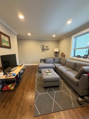 a living room with furniture a flat screen tv and a window