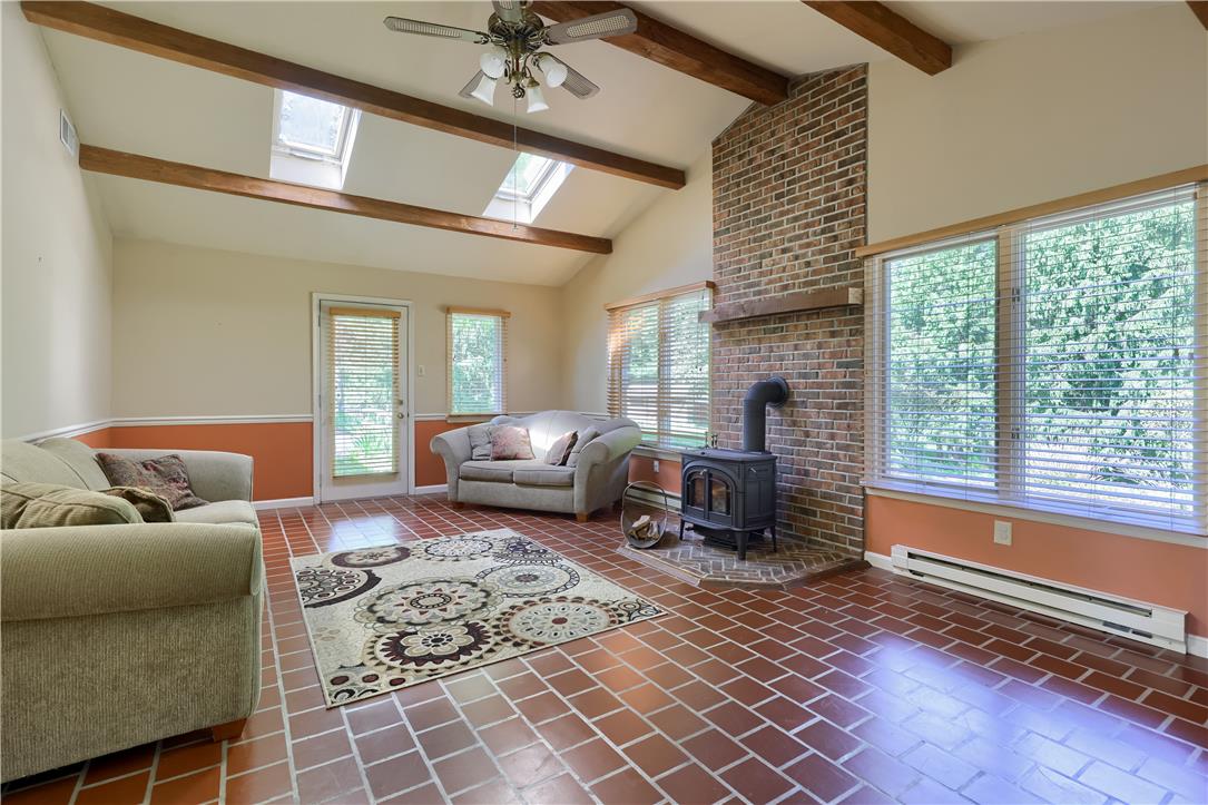 Coldsprings Rd Union Pottstown, PA 19465 - Photo 52 of 71 A vaulted ceiling, skylights, and a prominent brick fireplace with a wood-burning stove define this welcoming living space.