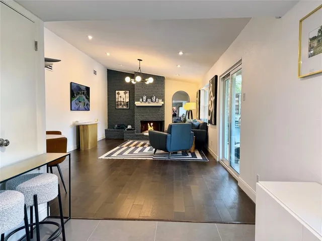 a work room with furniture a flat screen tv and a large window