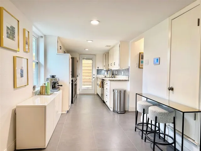 a kitchen with kitchen island a refrigerator a stove a dining table and chairs