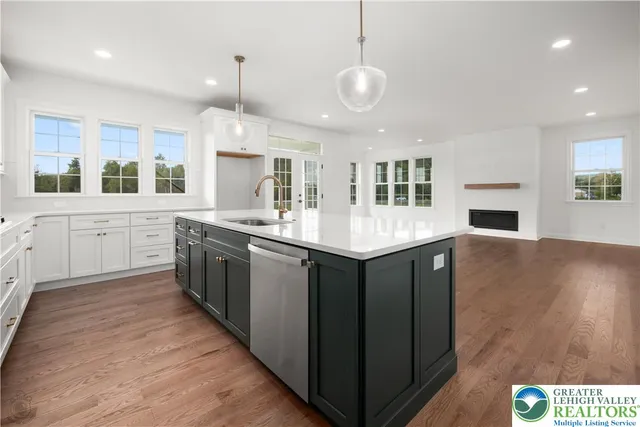 a kitchen with kitchen island granite countertop a stove and a wooden floors