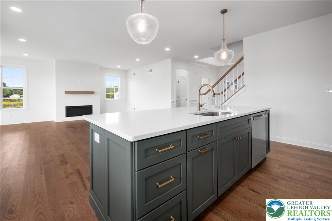 4268 Stonebridge Drive Bethlehem, PA 18015 - Photo 12 of 37 a kitchen with a sink a chandelier stainless steel appliances and cabinets